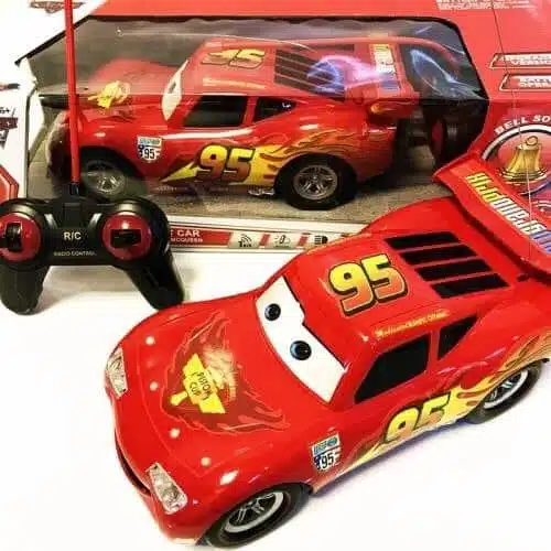 Photo d'une voiture télécommandée Flash McQueen de cars avec sa télécommande et sa boite