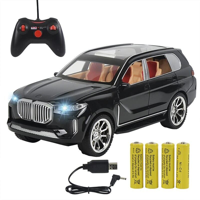 Photo d'une voiture télécommandée BMW X5 noir brillante avec sa télécommande, sa batterie et son câble de chargement USB.